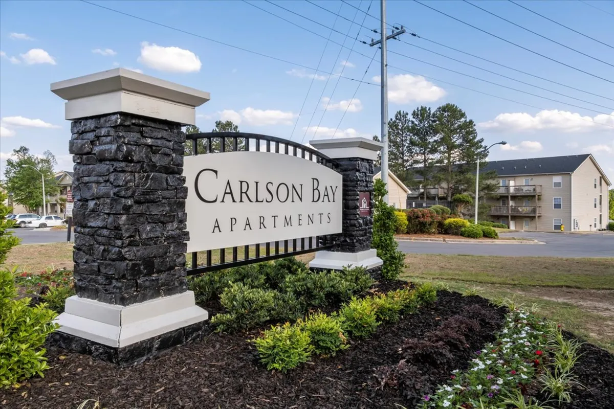 A welcoming apartment complex featuring prominent signage, attractive landscaping, and clear building facades. The inviting atmosphere suggests a friendly and professional environment, suitable for new residents and frequent comings and goings.